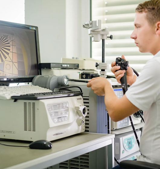 Technicien MIDES réparant une sonde à ultrasons en atelier certifié